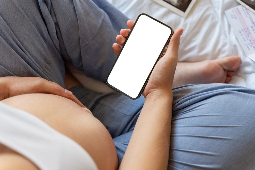 Pregnant person with smart phone